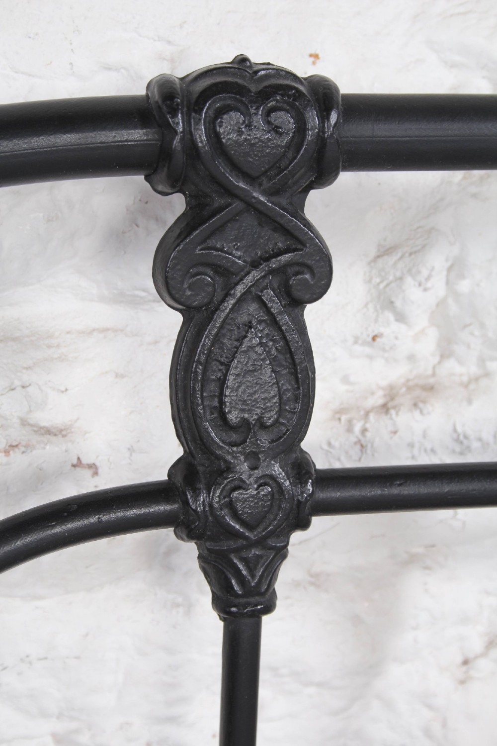 A Victorian Art Nouveau style black cast iron king size bed frame featuring vertical spindles and decorative joinery details. View V