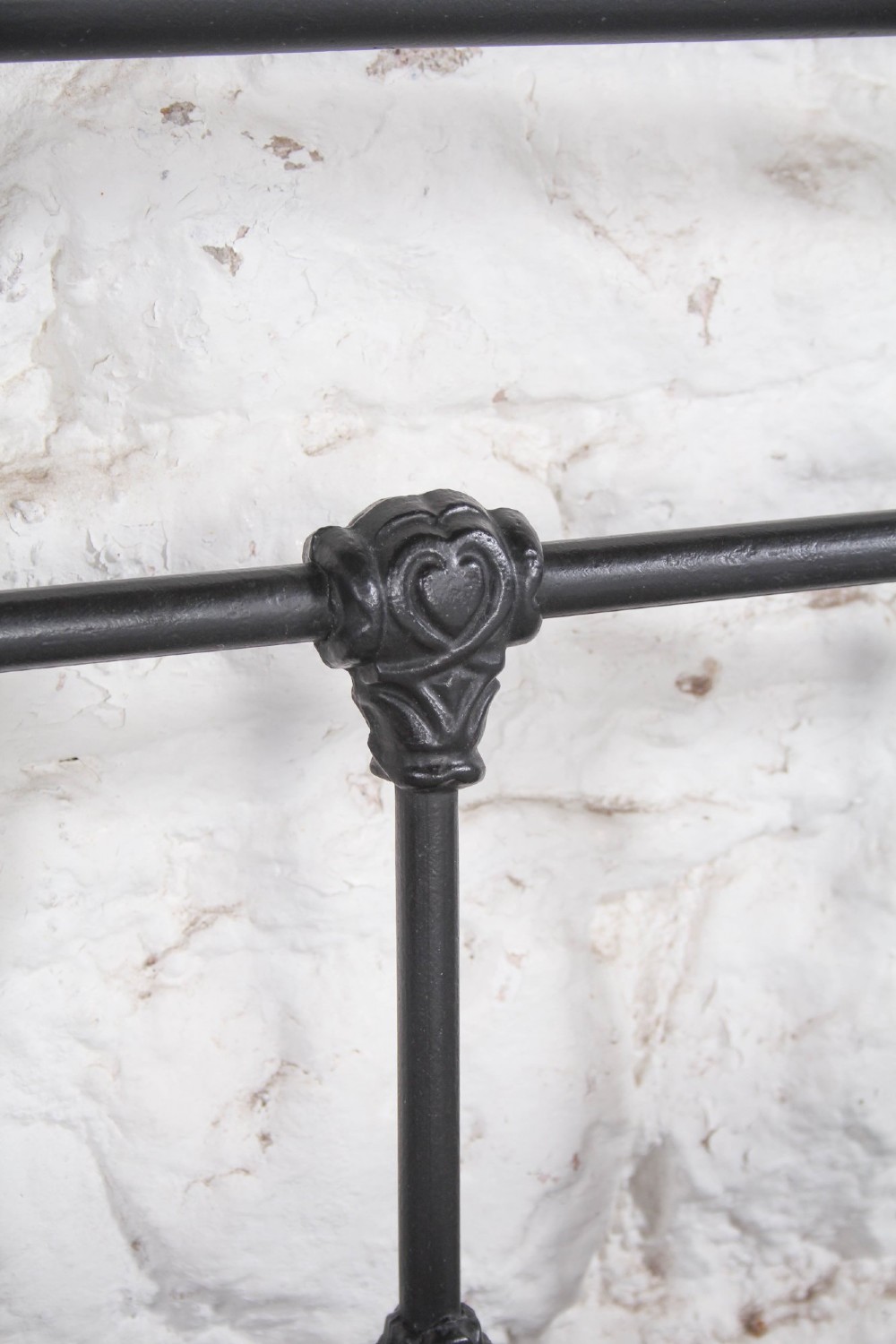 A Victorian Art Nouveau style black cast iron king size bed frame featuring vertical spindles and decorative joinery details. View VI