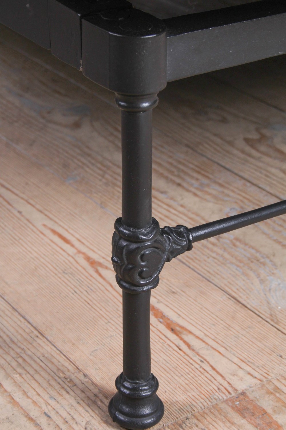 A Victorian Art Nouveau style black cast iron king size bed frame featuring vertical spindles and decorative joinery details. View VII