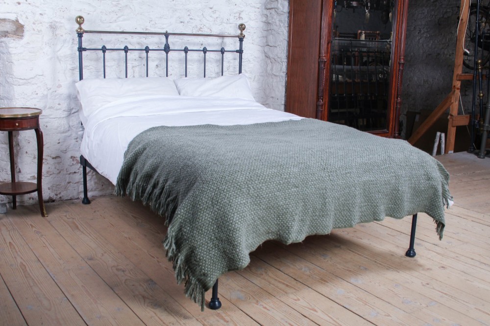 A Victorian double bed frame featuring a dark cast iron headboard with vertical spindles and a polished brass top rail with corner finials. View II