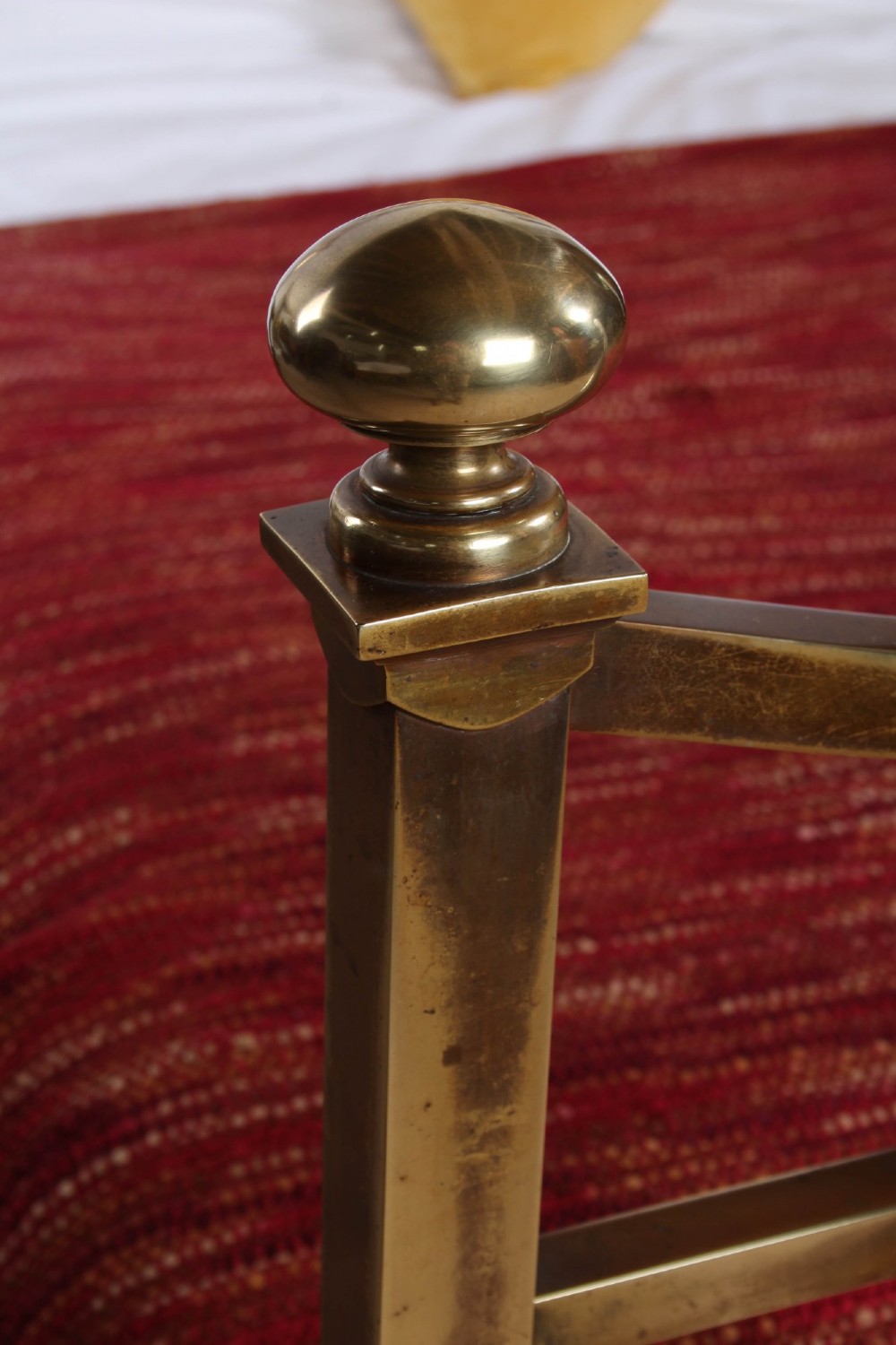 An antique French double bed constructed from brass tubing featuring a curved top rail, vertical spindles, ball finials, and original castors. View IX