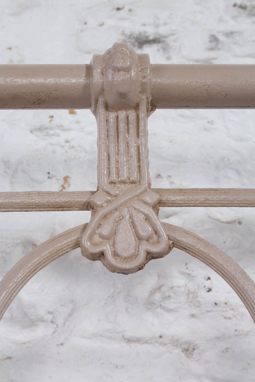 A cream painted wrought iron king size bed frame featuring a high arched headboard with central brass detailing and a low foot end. View VI