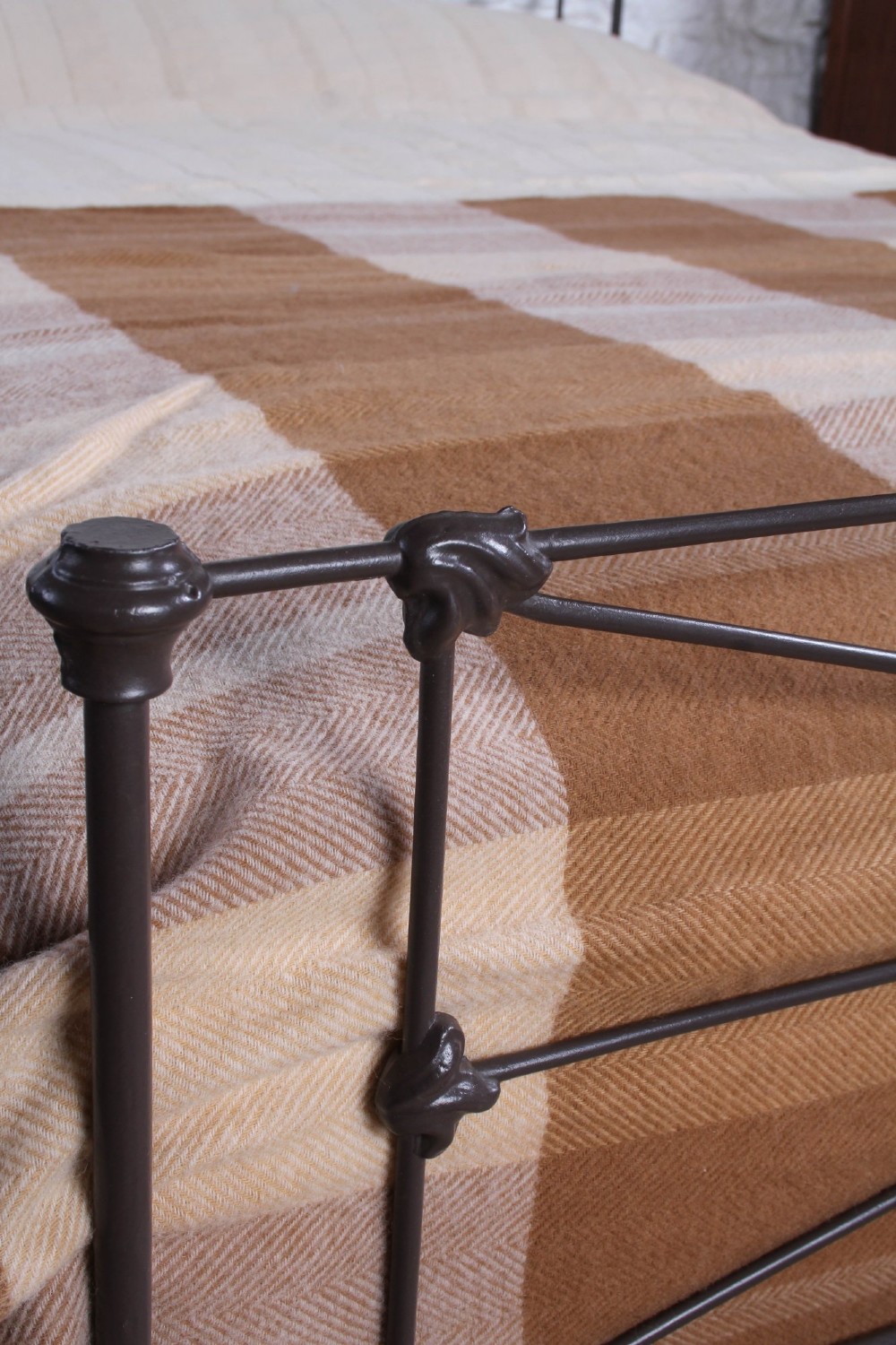 A Victorian dark iron king-size bedstead featuring geometric cross-bracing and cast decorative joints on the headboard and footboard. View V