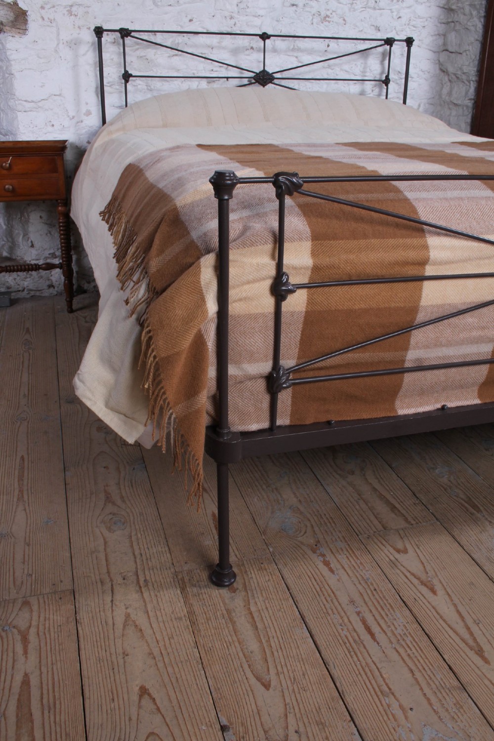 A Victorian dark iron king-size bedstead featuring geometric cross-bracing and cast decorative joints on the headboard and footboard. View VI