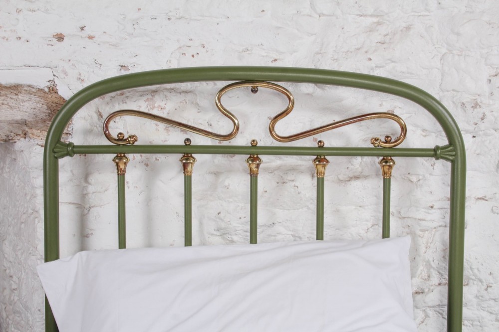 A pair of olive green painted iron single bed frames featuring brass finials, vertical spindles, and decorative scrolled crests. View V