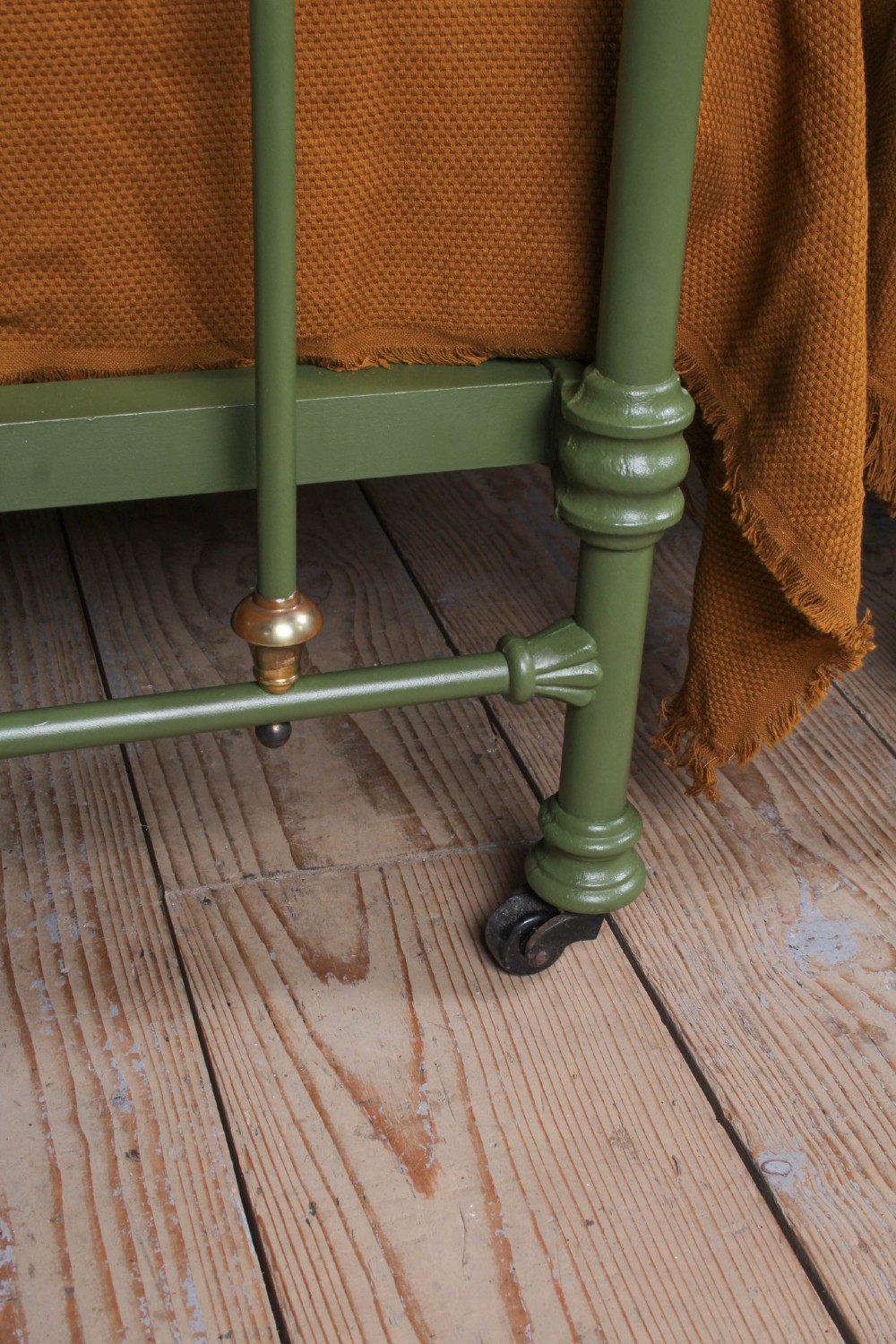 A pair of olive green painted iron single bed frames featuring brass finials, vertical spindles, and decorative scrolled crests. View IX