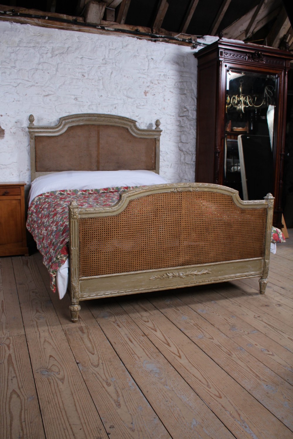 A French Louis XVI style double bed frame with a carved wood surround, woven cane headboard and footboard, fluted legs, and a distressed grey painted finish. View VII