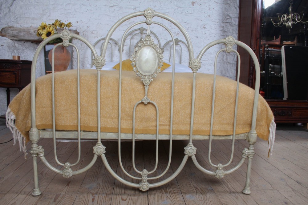 A Victorian cream-painted iron double bed frame featuring a three-hoop headboard and footboard design with central ornate medallions. View II