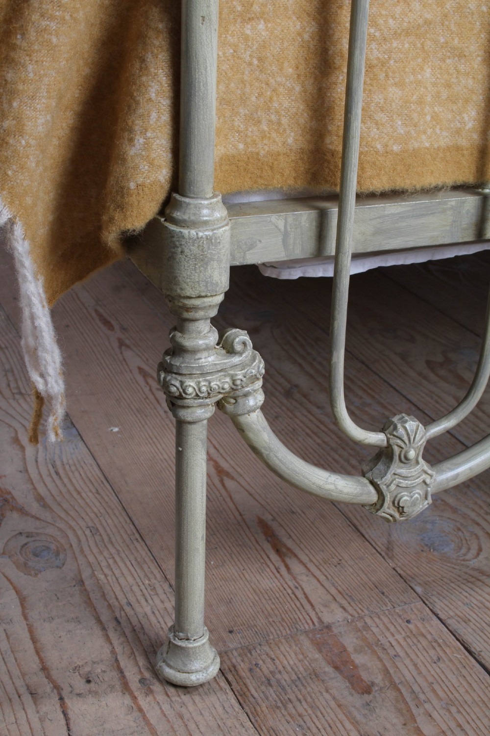A Victorian cream-painted iron double bed frame featuring a three-hoop headboard and footboard design with central ornate medallions. View V
