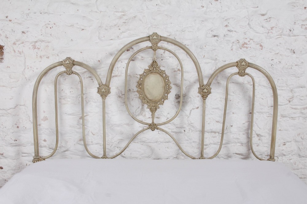 A Victorian cream-painted iron double bed frame featuring a three-hoop headboard and footboard design with central ornate medallions. View IX