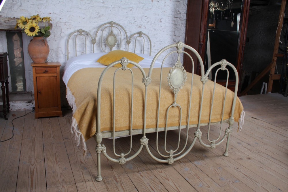 A Victorian cream-painted iron double bed frame featuring a three-hoop headboard and footboard design with central ornate medallions. View XI