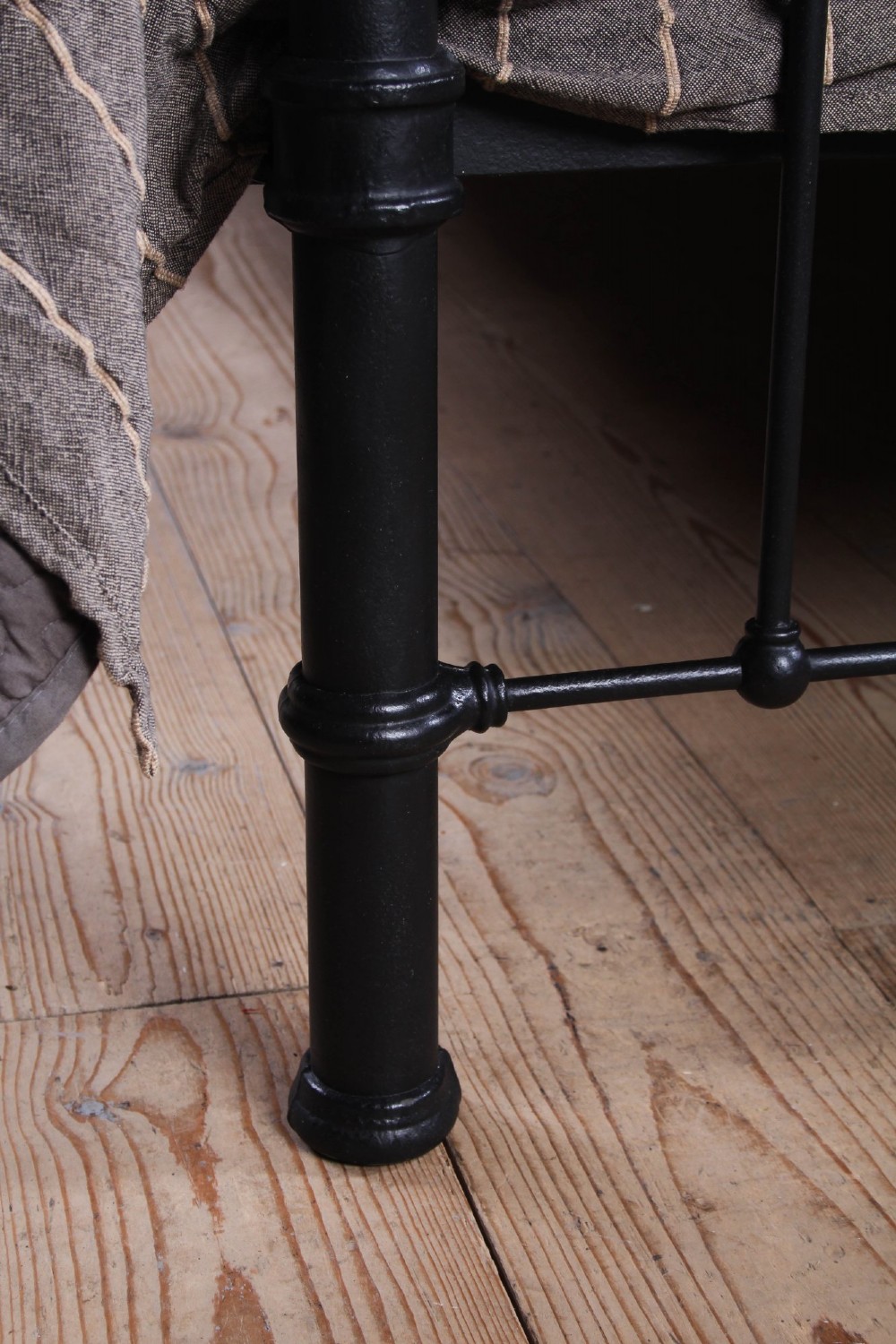 An Edwardian style super king size bed frame made of black painted iron with vertical spindles, topped with curved brass dipping rails and brass finials. View VI