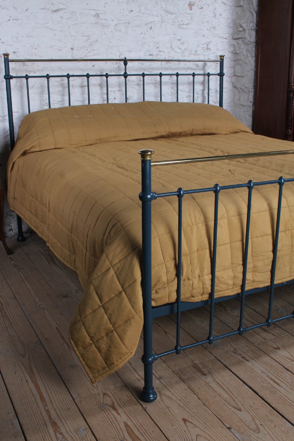 An Edwardian super king bedstead featuring a dark blue cast iron frame with vertical spindles and polished brass top rails. View II