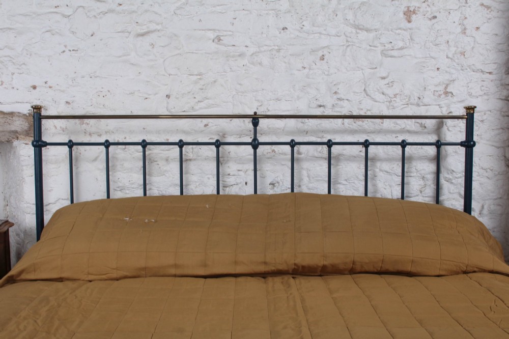 An Edwardian super king bedstead featuring a dark blue cast iron frame with vertical spindles and polished brass top rails. View IV