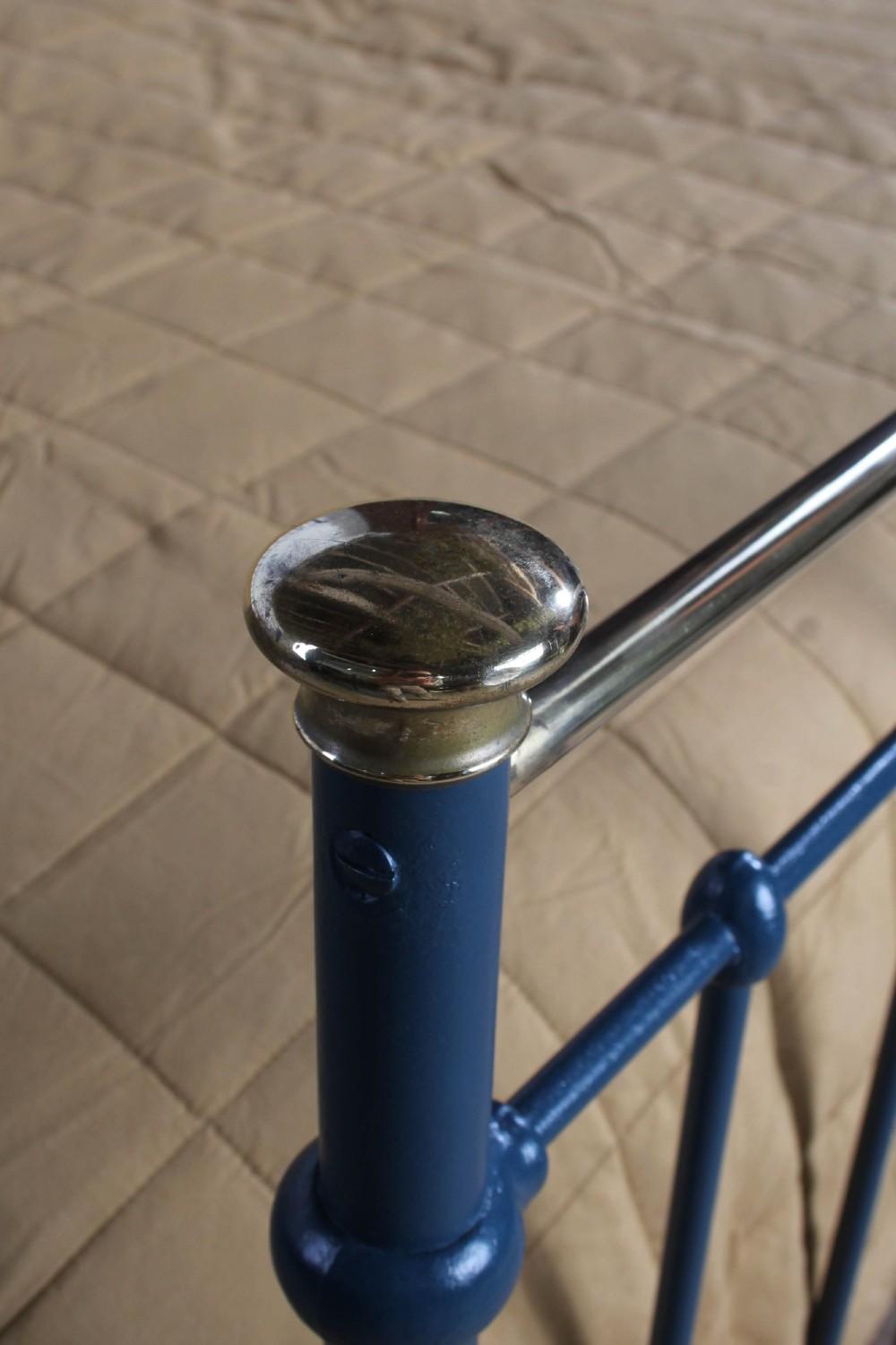 An Edwardian super king bedstead featuring a dark blue cast iron frame with vertical spindles and polished brass top rails. View V
