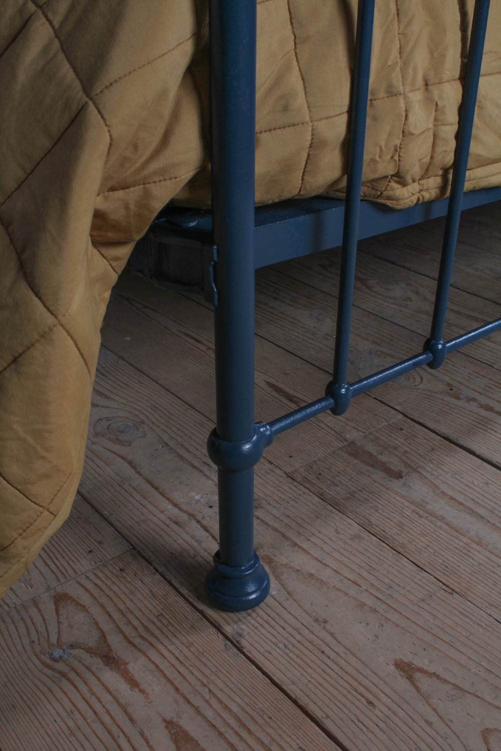 An Edwardian super king bedstead featuring a dark blue cast iron frame with vertical spindles and polished brass top rails. View VI