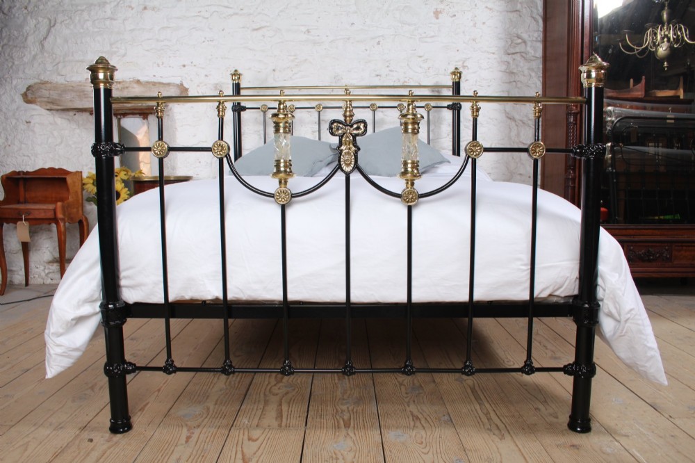 A Victorian black cast iron double bed frame with brass top rails, brass finials, and mother-of-pearl inlay details. View II