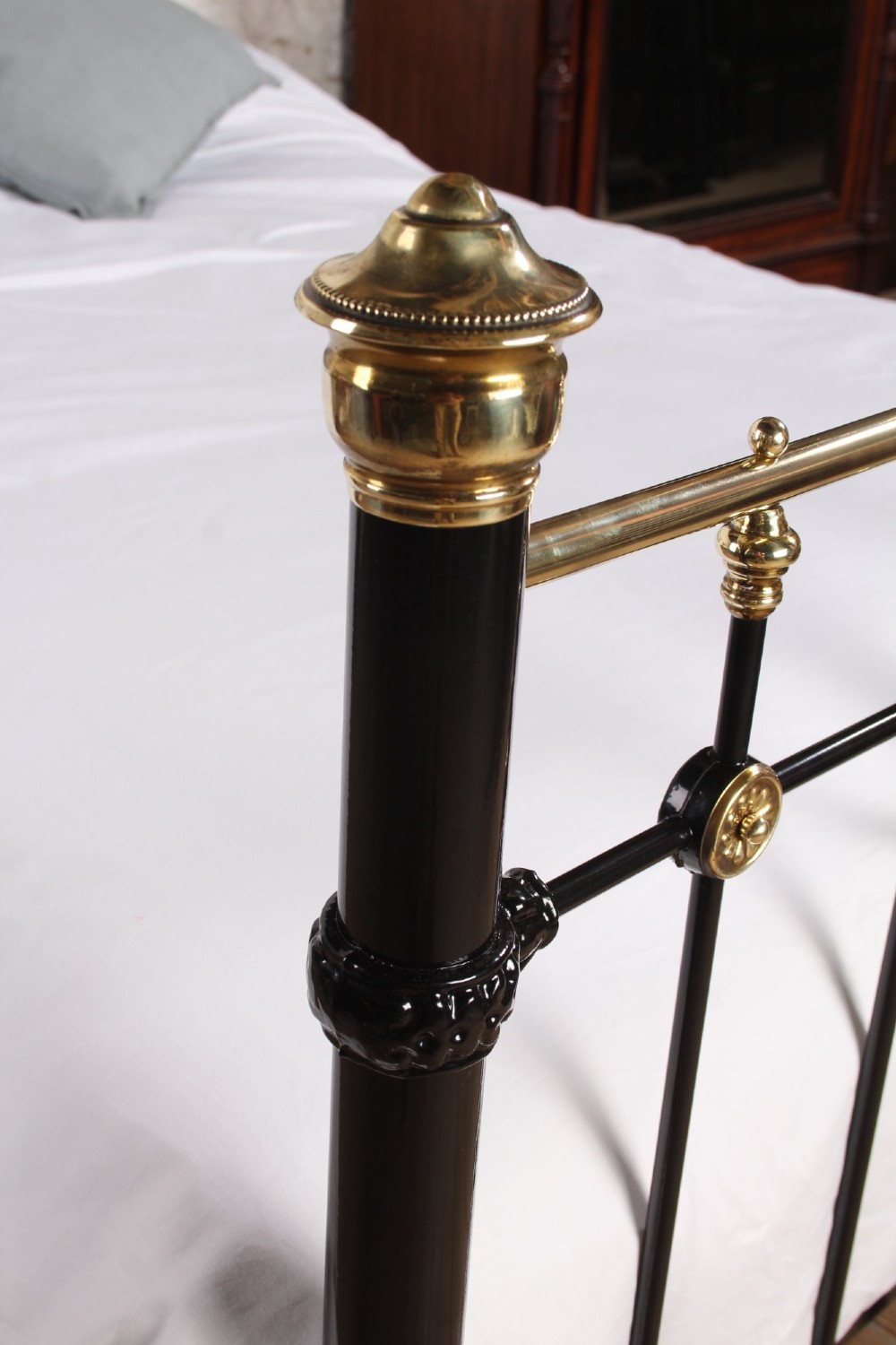 A Victorian black cast iron double bed frame with brass top rails, brass finials, and mother-of-pearl inlay details. View IV