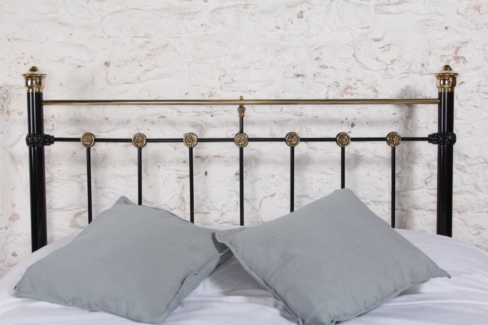 A Victorian black cast iron double bed frame with brass top rails, brass finials, and mother-of-pearl inlay details. View IX