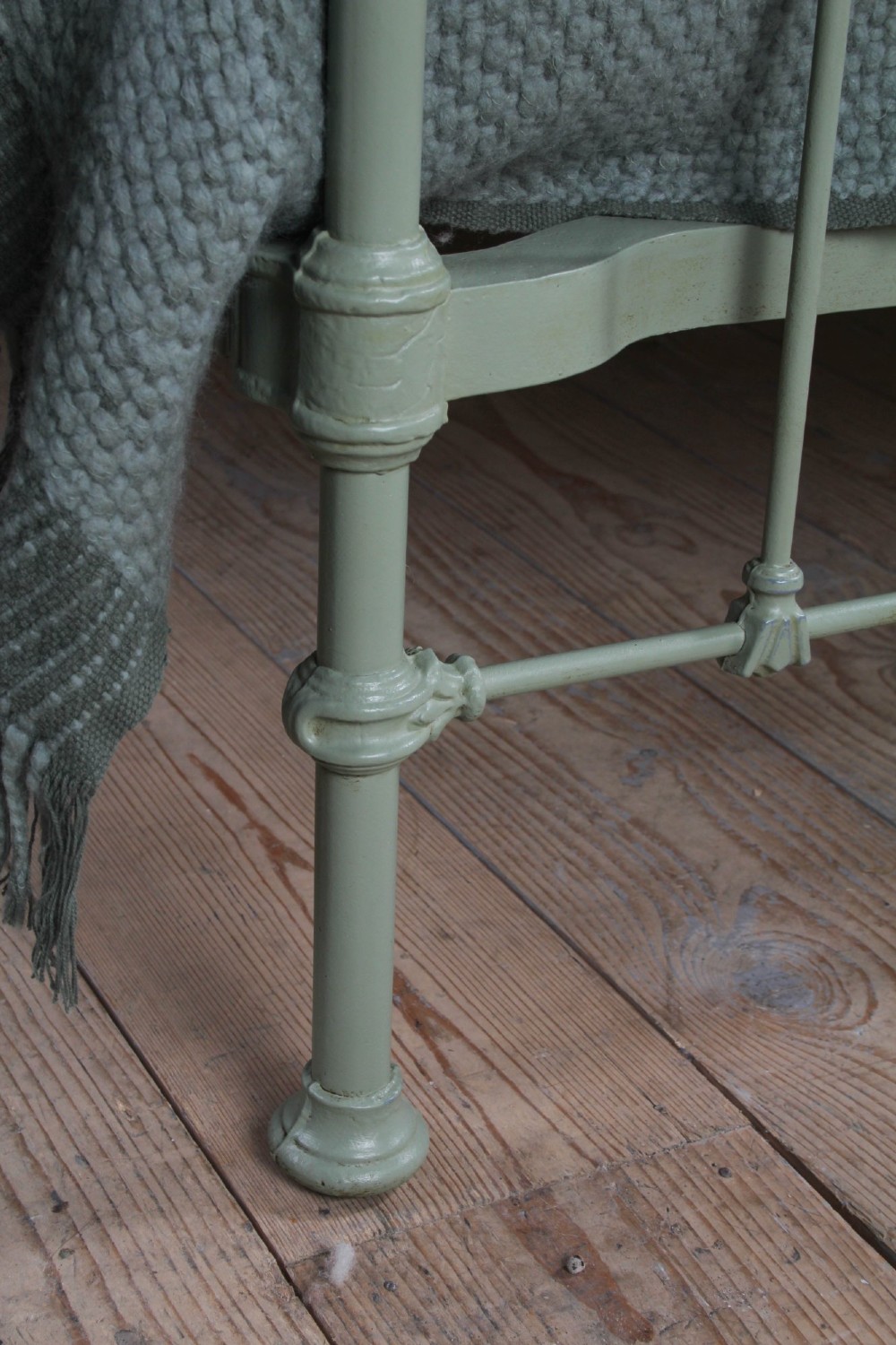A Victorian sage green painted iron double bedstead featuring decorative scrollwork and polished brass top rails with spherical finials. View VIII