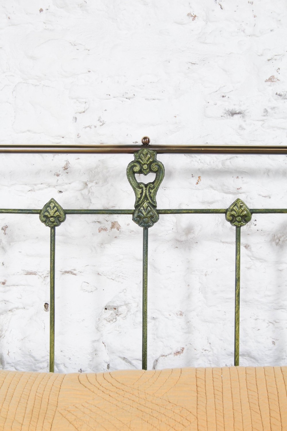 A king-size Victorian green painted iron bed frame featuring decorative central castings, vertical spindles, and a brass top rail with finials. View VI