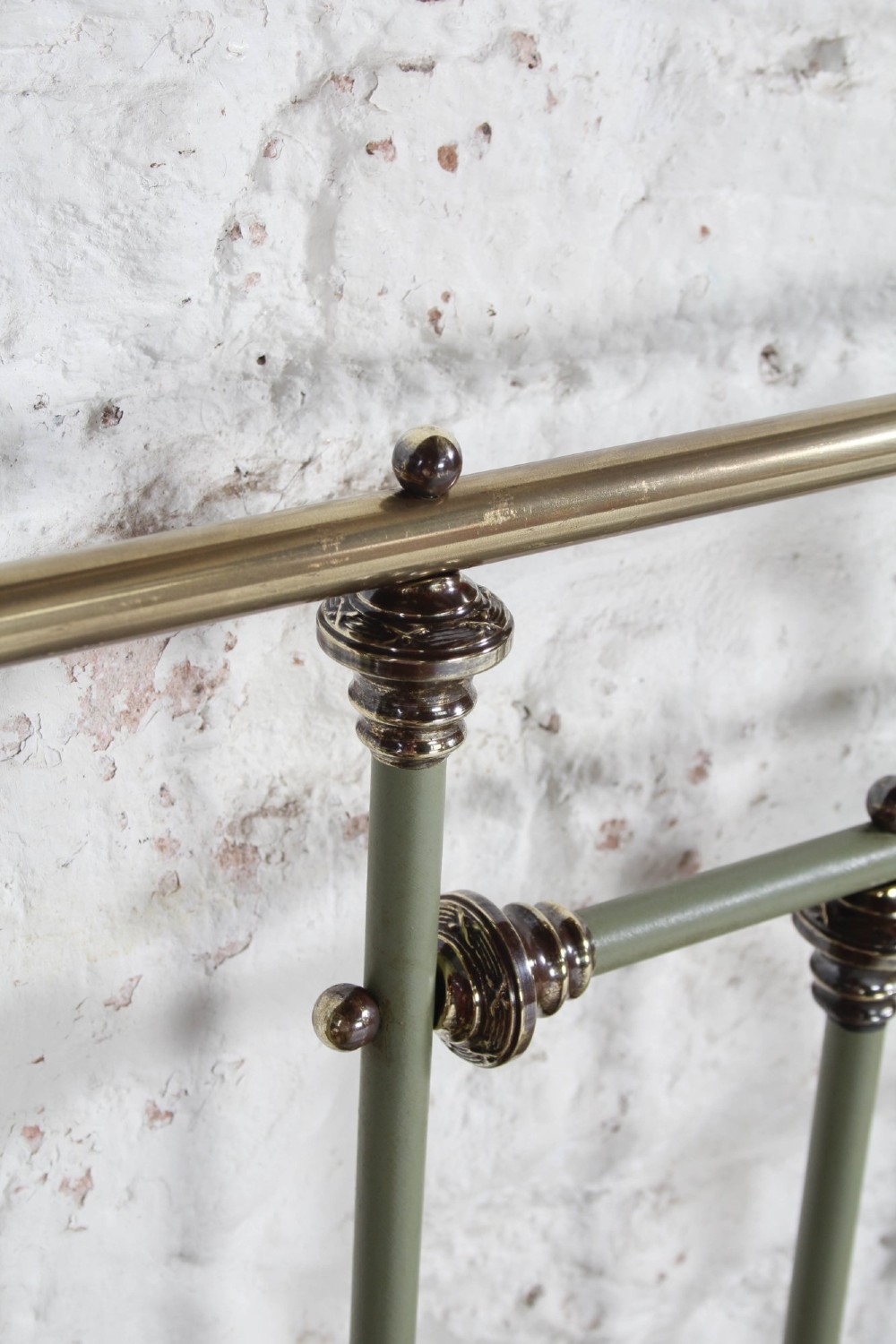 A super king French iron bedstead featuring a sage green painted frame, vertical iron spindles, brass top rails, and brass oval motifs. View VI
