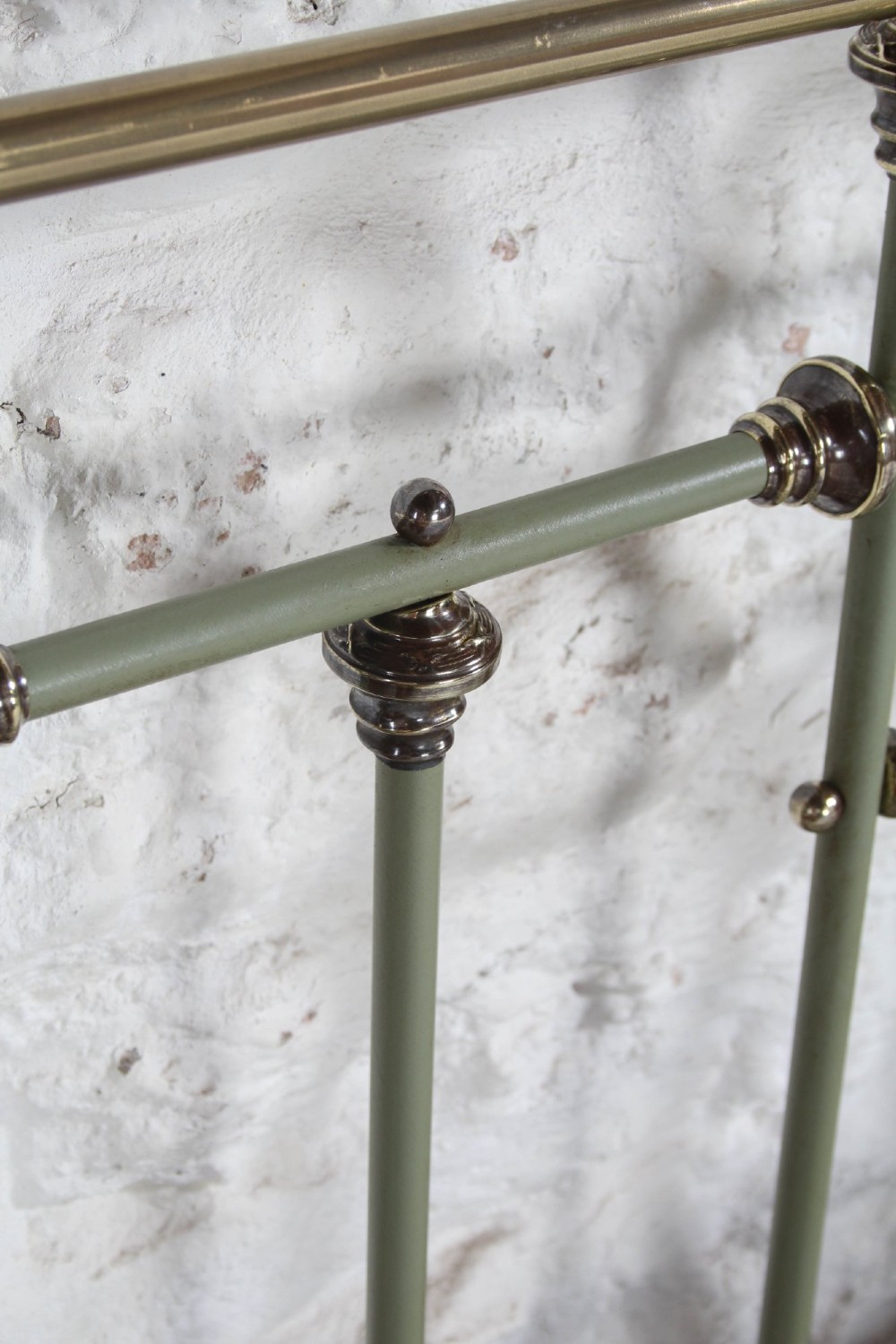 A super king French iron bedstead featuring a sage green painted frame, vertical iron spindles, brass top rails, and brass oval motifs. View VII