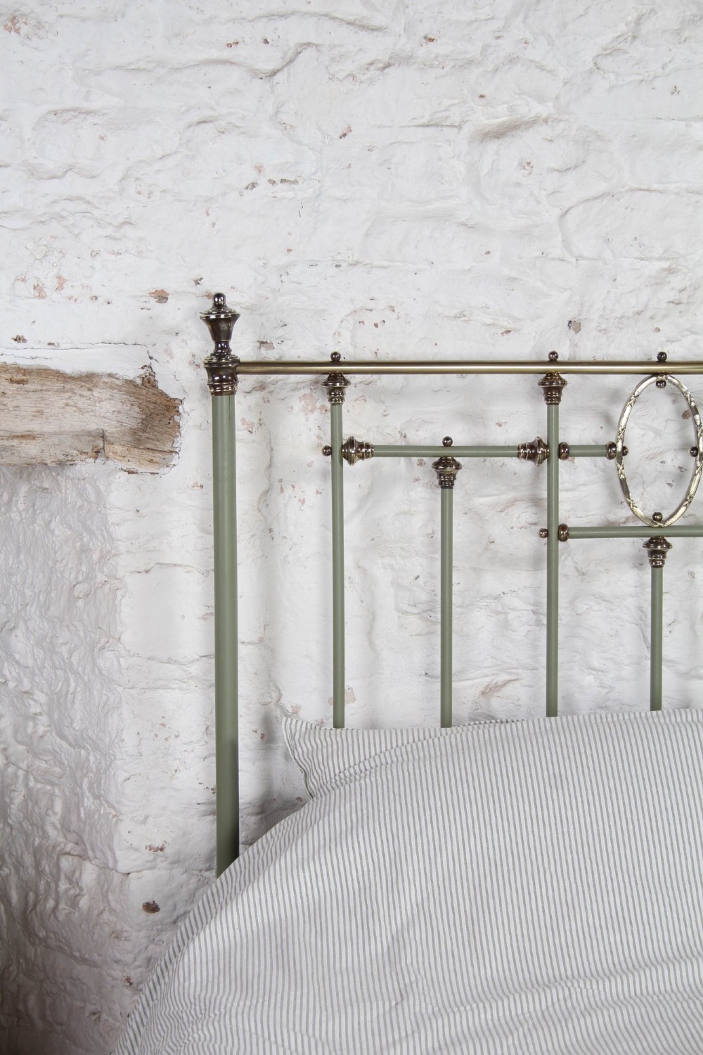 A super king French iron bedstead featuring a sage green painted frame, vertical iron spindles, brass top rails, and brass oval motifs. View VIII