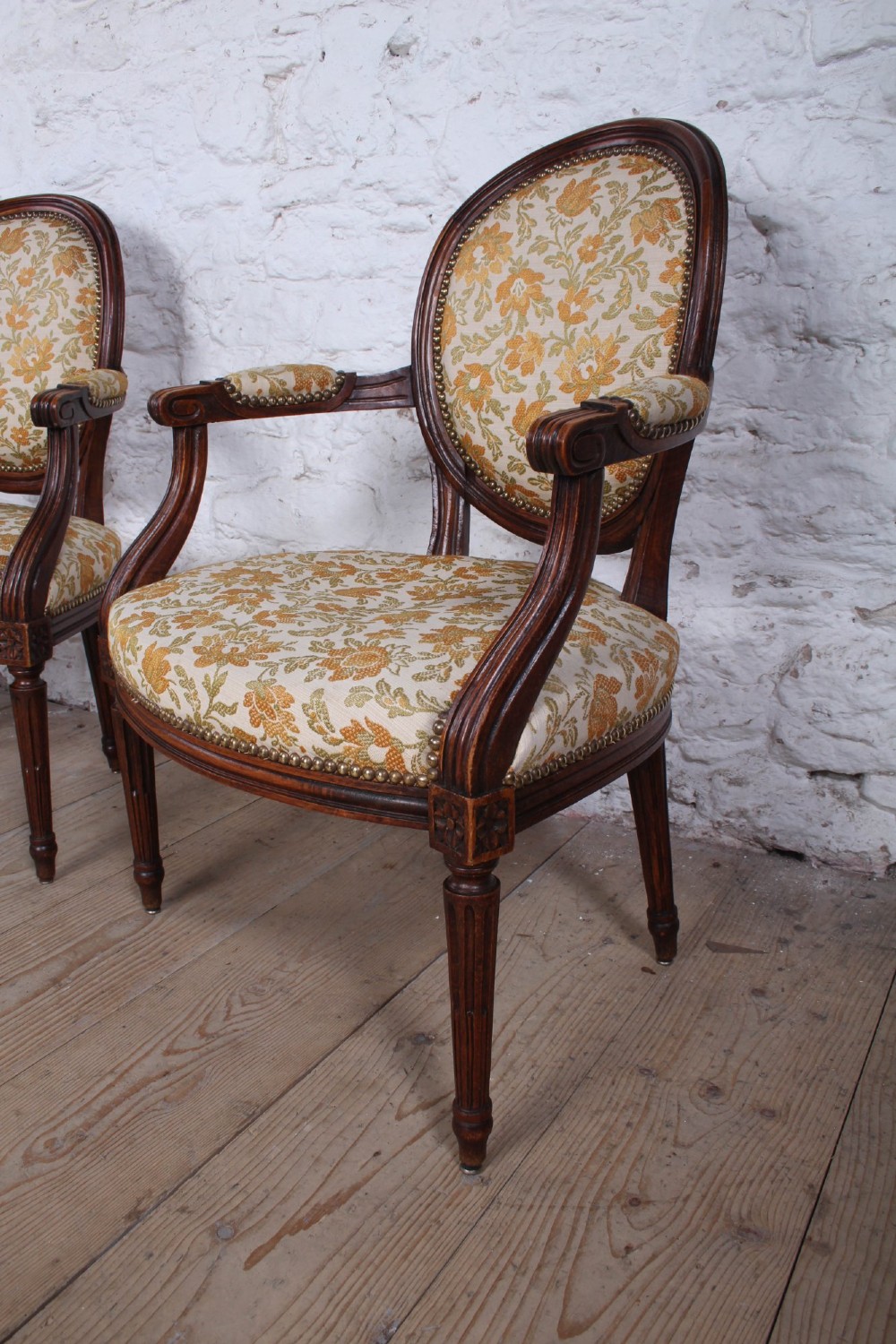 A pair of Louis XVI style carved timber armchairs with oval medallion backs and floral patterned upholstery. View II