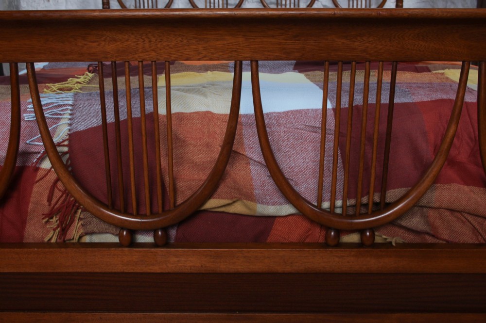 A double bed frame constructed from cherry wood featuring curved headboard and footboard panels fitted with vertical spindles. View II