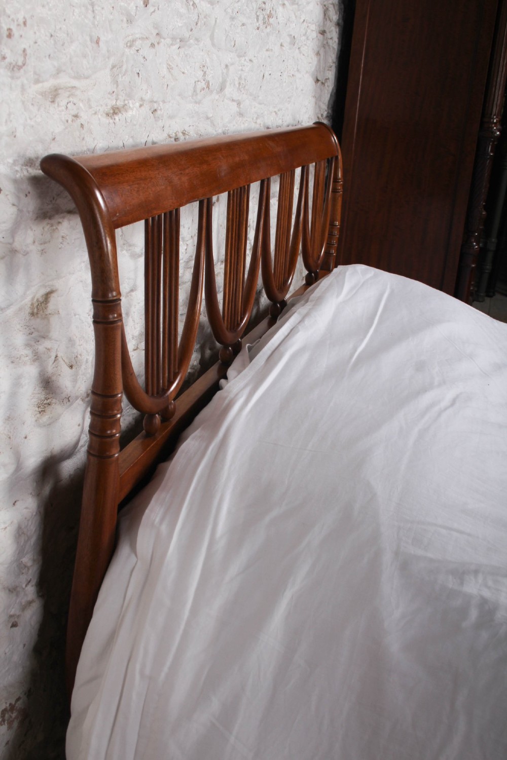 A double bed frame constructed from cherry wood featuring curved headboard and footboard panels fitted with vertical spindles. View V