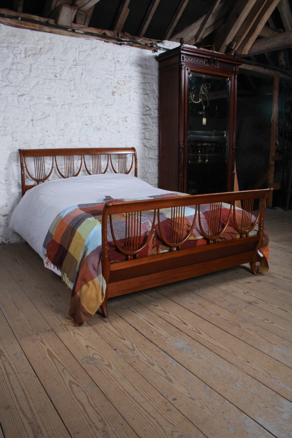 A double bed frame constructed from cherry wood featuring curved headboard and footboard panels fitted with vertical spindles. View VIII