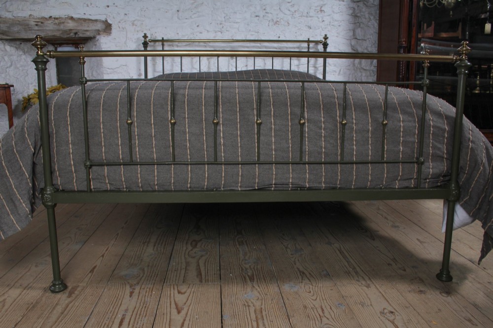 A dark green painted iron and brass king-size bedstead featuring vertical iron spindles and polished brass top rails. View III