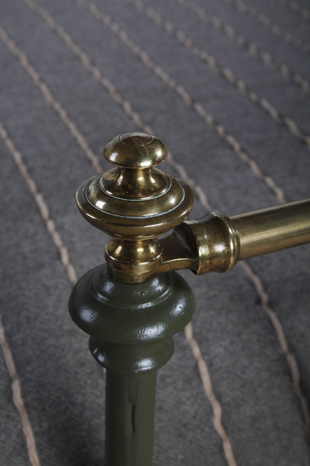 A dark green painted iron and brass king-size bedstead featuring vertical iron spindles and polished brass top rails. View VI