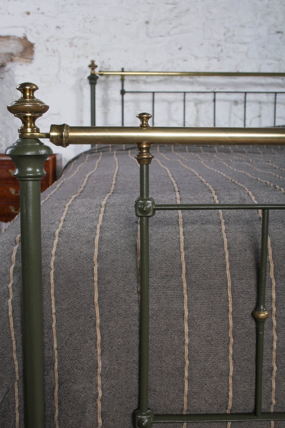 A dark green painted iron and brass king-size bedstead featuring vertical iron spindles and polished brass top rails. View VII
