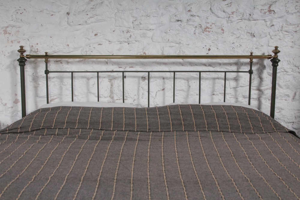 A dark green painted iron and brass king-size bedstead featuring vertical iron spindles and polished brass top rails. View VIII