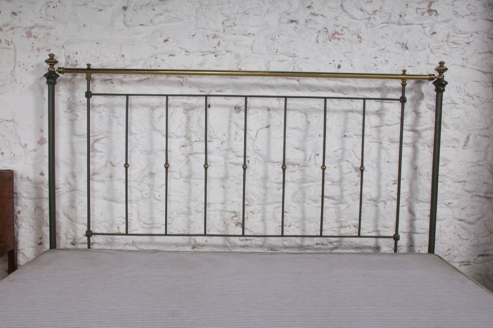 A dark green painted iron and brass king-size bedstead featuring vertical iron spindles and polished brass top rails. View XI