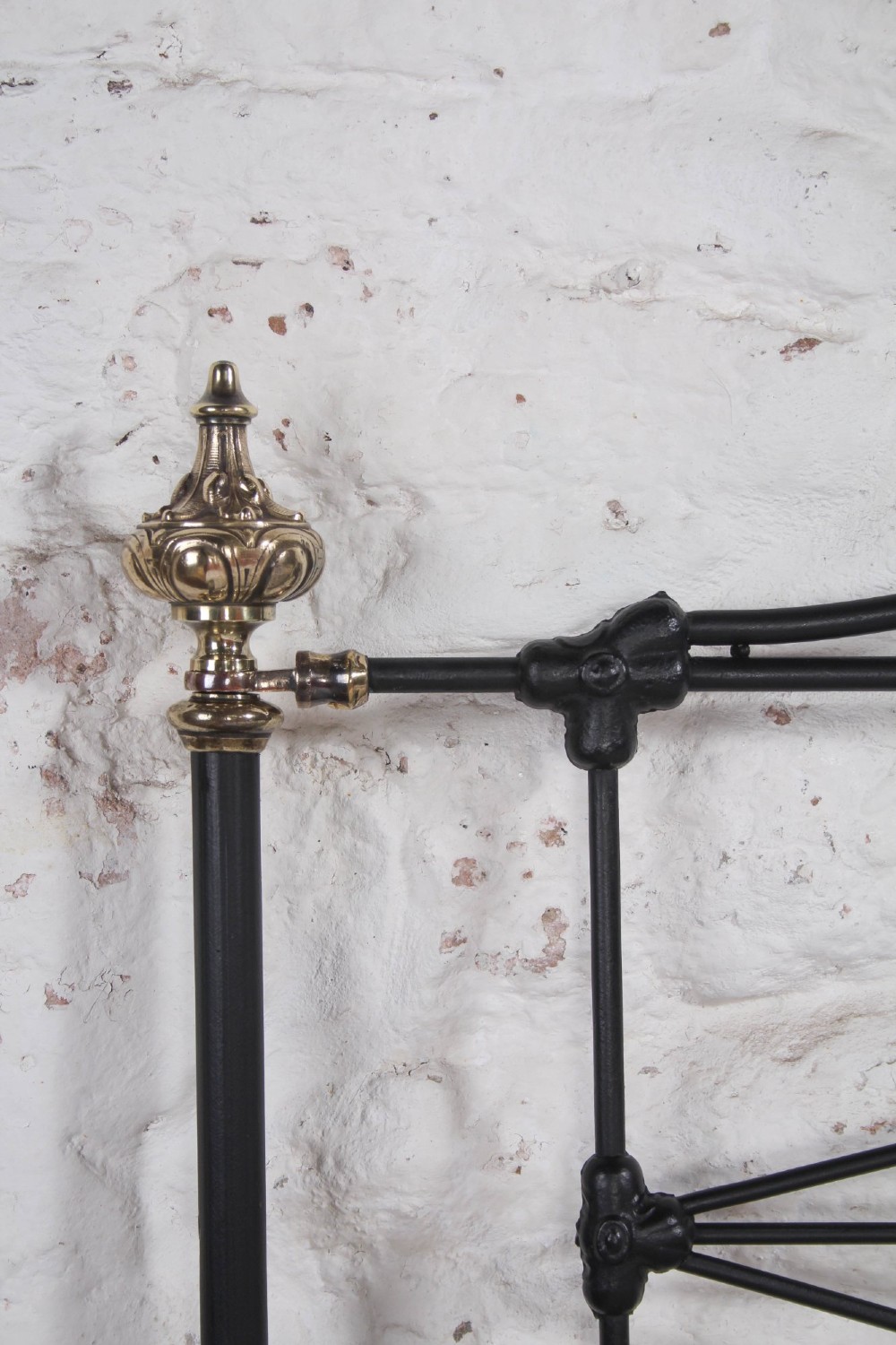 A Victorian iron and brass king-size bedstead featuring barley twist posts, ornate brass scrollwork on the footboard, and a arched black iron headboard. View VII