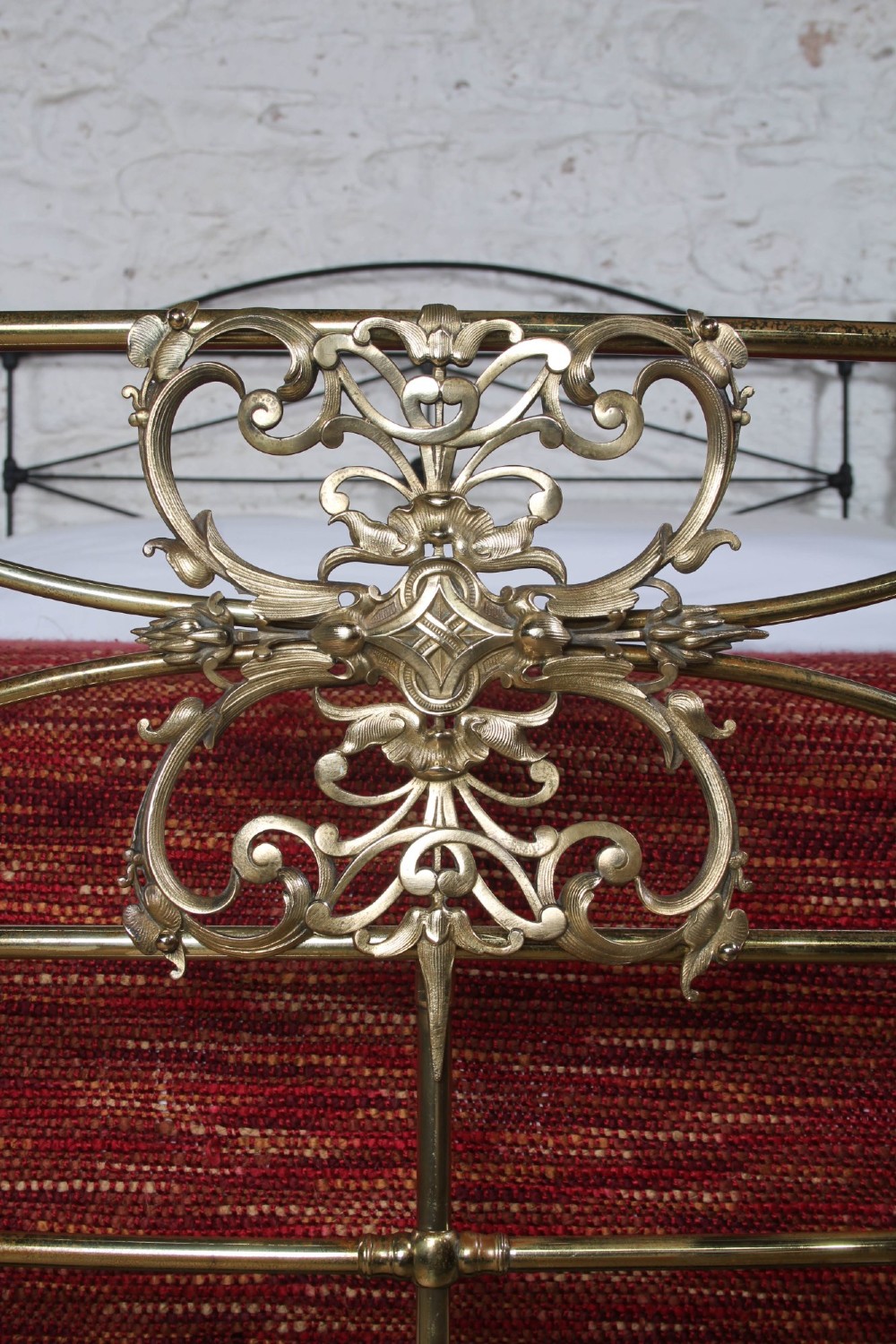 A Victorian iron and brass king-size bedstead featuring barley twist posts, ornate brass scrollwork on the footboard, and a arched black iron headboard. View XI