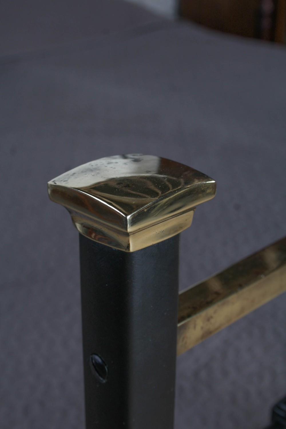 A pair of Edwardian black iron single beds featuring square tube framing, vertical spindles, and polished brass top rails. View VII