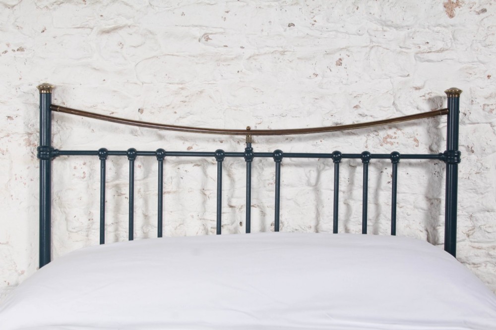 An Edwardian dark blue painted iron double bed frame featuring curved brass dip rails, vertical spindles, and ceramic castors. View III