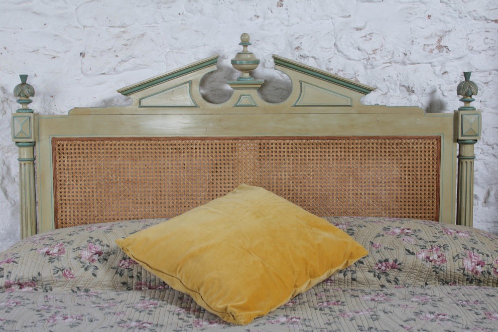 An Empire style bed frame with sage green painted timber, woven cane panels on the headboard and footboard, and carved corner finials. View IV