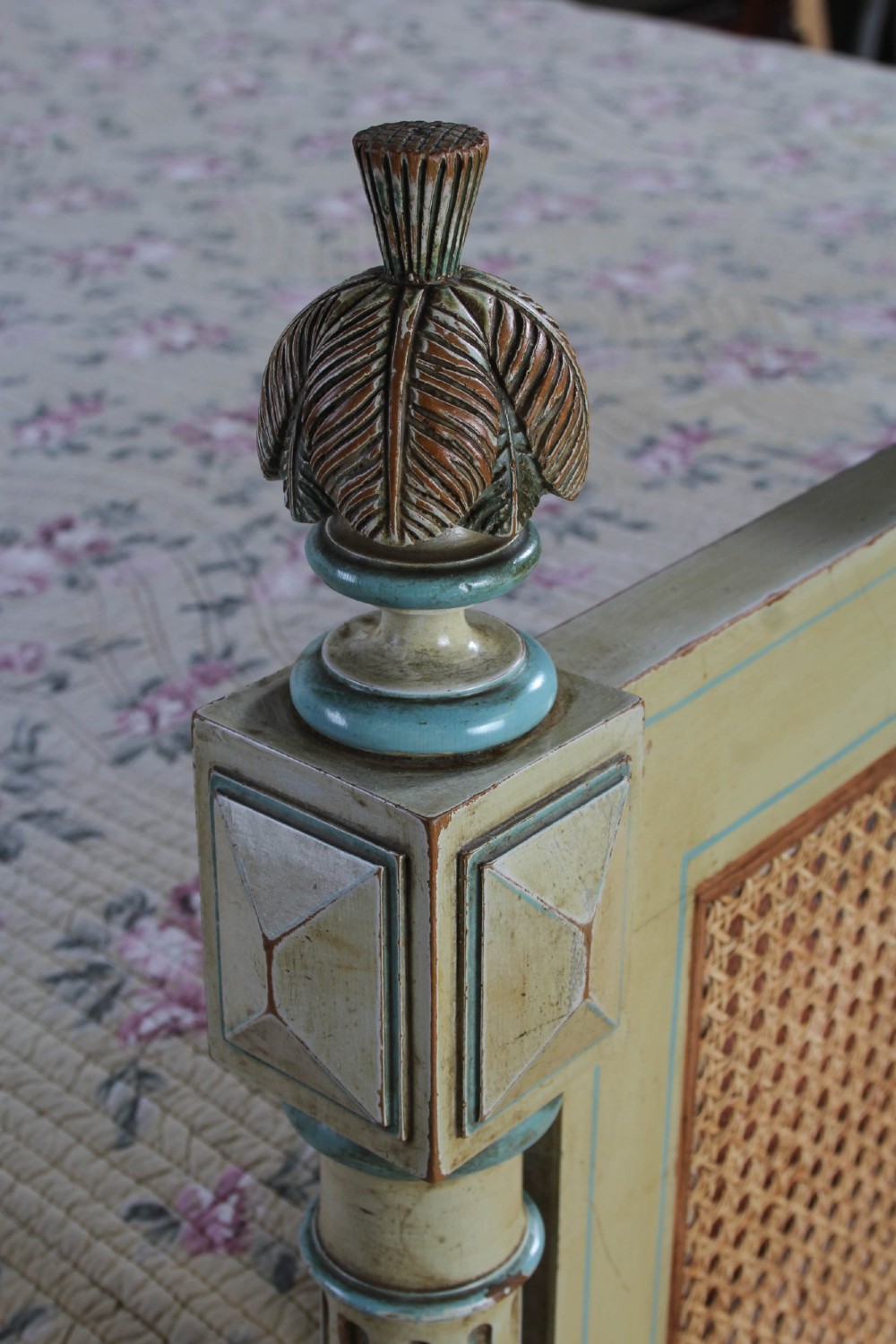 An Empire style bed frame with sage green painted timber, woven cane panels on the headboard and footboard, and carved corner finials. View V