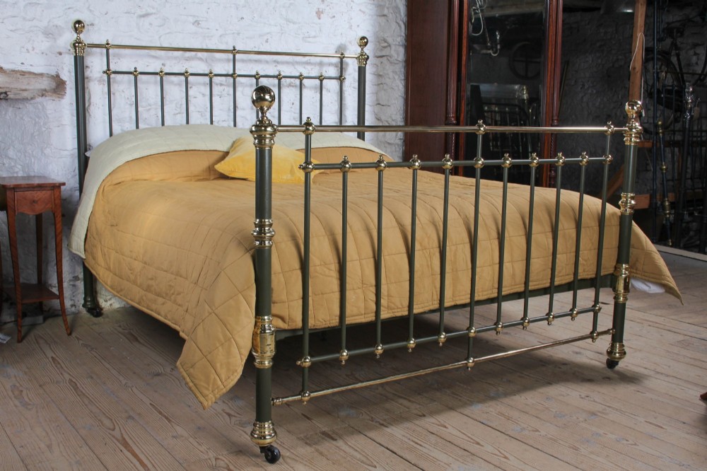Victorian super-king size bedstead featuring dark green painted iron spindles and polished brass rails and finials.