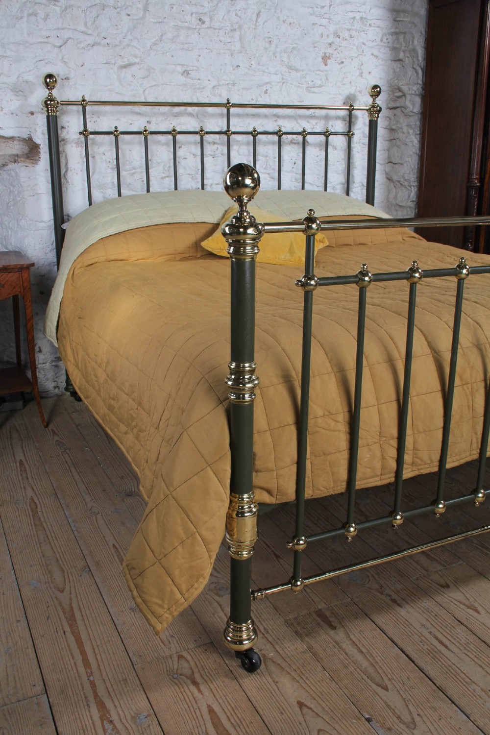 Victorian super-king size bedstead featuring dark green painted iron spindles and polished brass rails and finials. View V