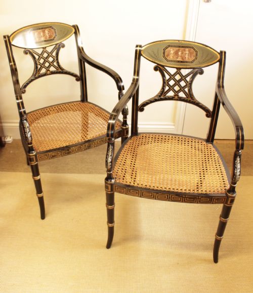 A Pair of Regency Style Ebonised Open Arm Chairs