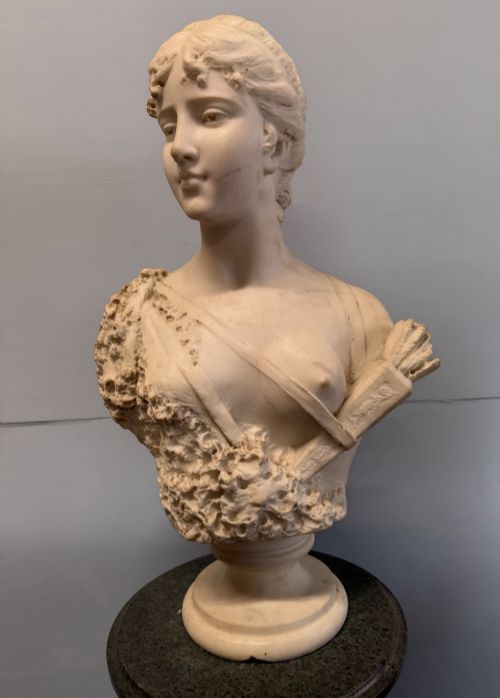 fig 1. Carved white marble bust depicting Diana the Huntress with a quiver over her shoulder resting on a round moulded base.