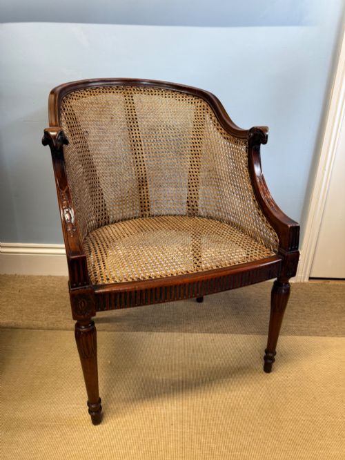 A MAHOGANY CANED BERGRE ARMCHAIR
