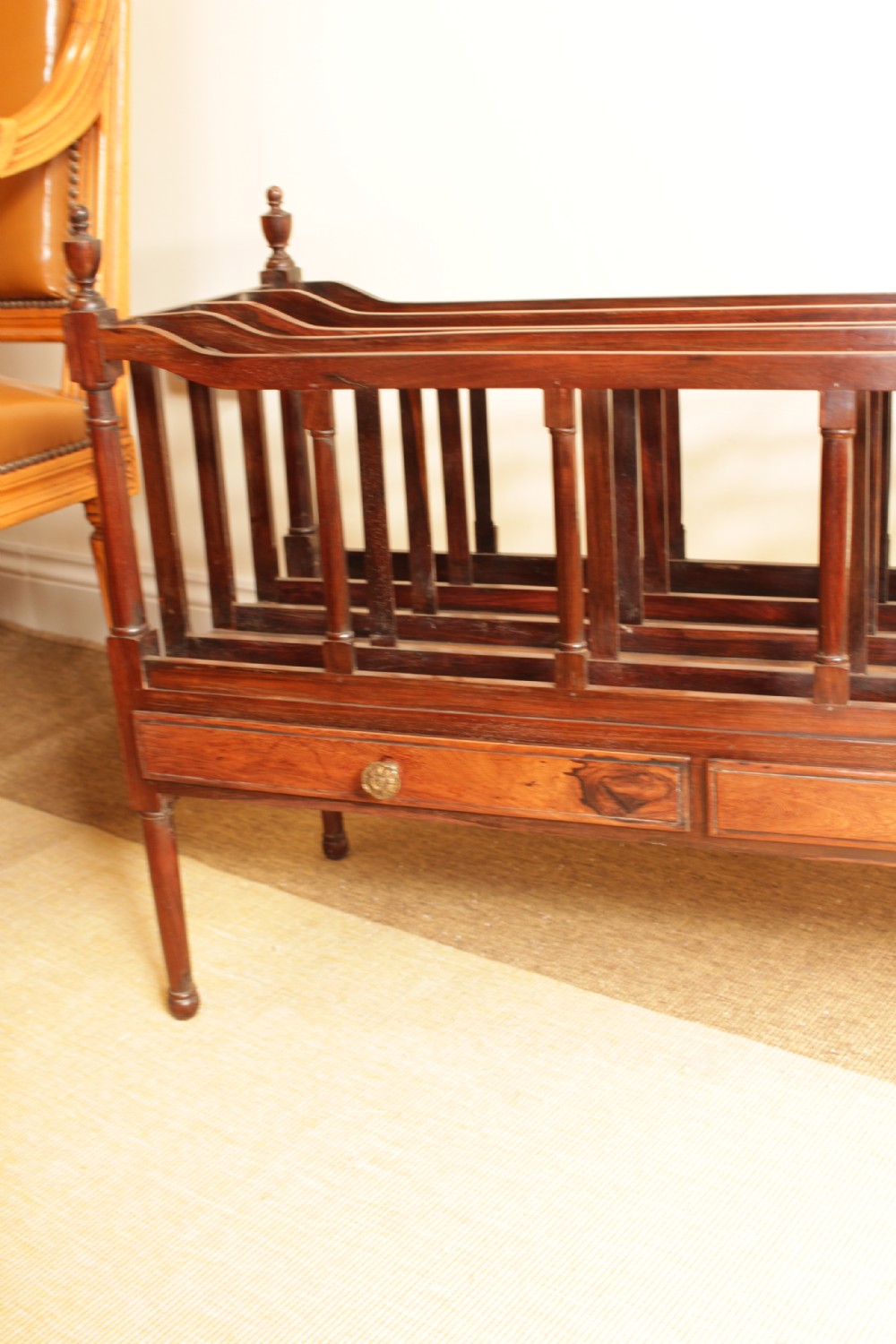 An antique Regency period dark rosewood double Canterbury featuring divided upper bays, turned corner posts with finials, two base drawers, and turned legs. View IV