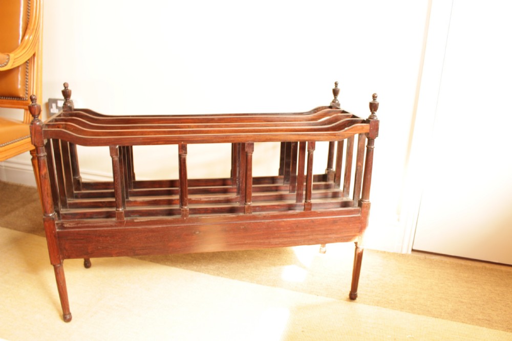 An antique Regency period dark rosewood double Canterbury featuring divided upper bays, turned corner posts with finials, two base drawers, and turned legs. View VII